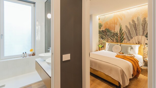 A modern bathroom with a large window, a sink, and a mirror.