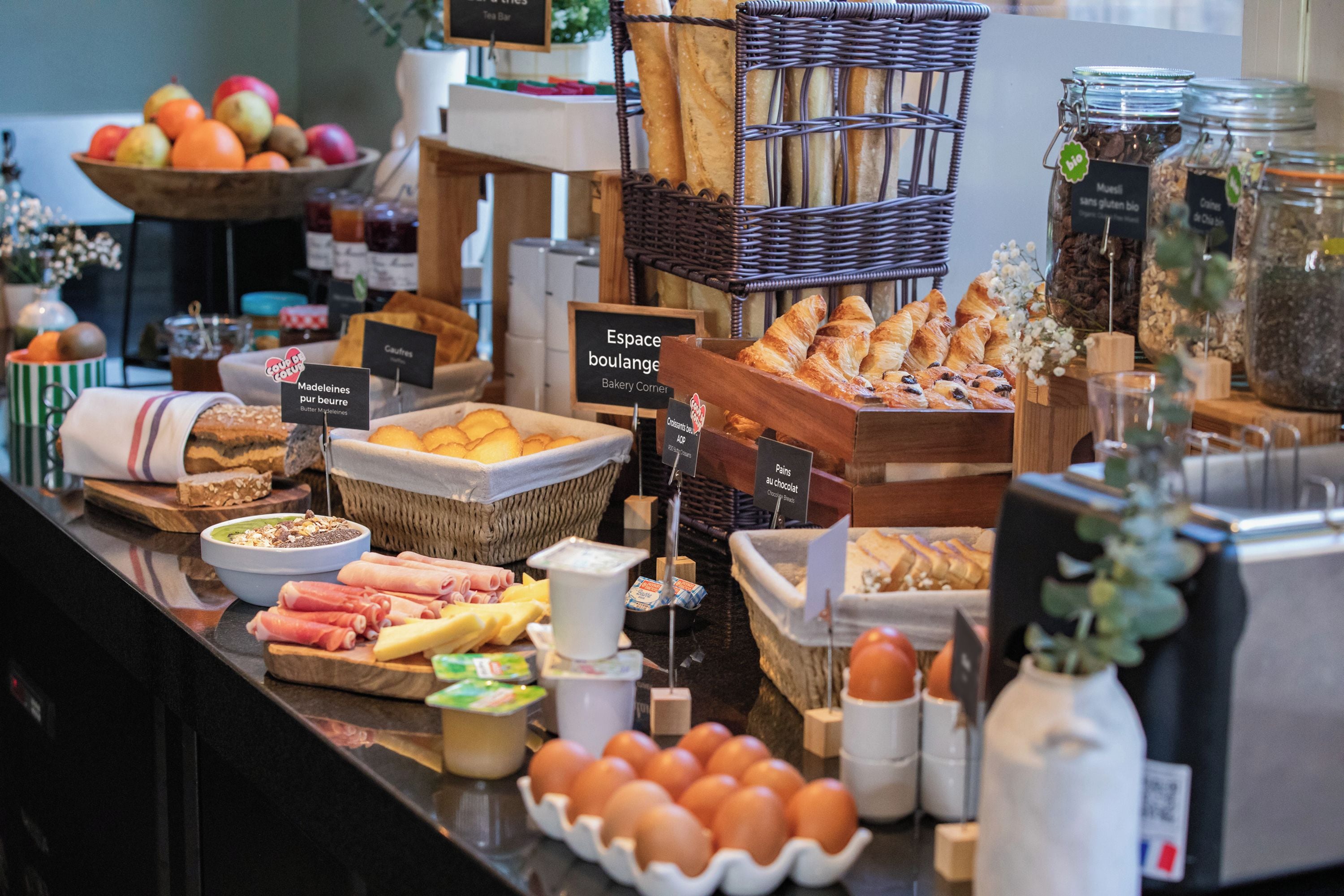 A bakery counter with various breads, pastries, and breakfast items.