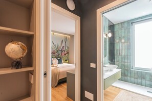 A modern bathroom with a large mirror, a sink, and a shower.
