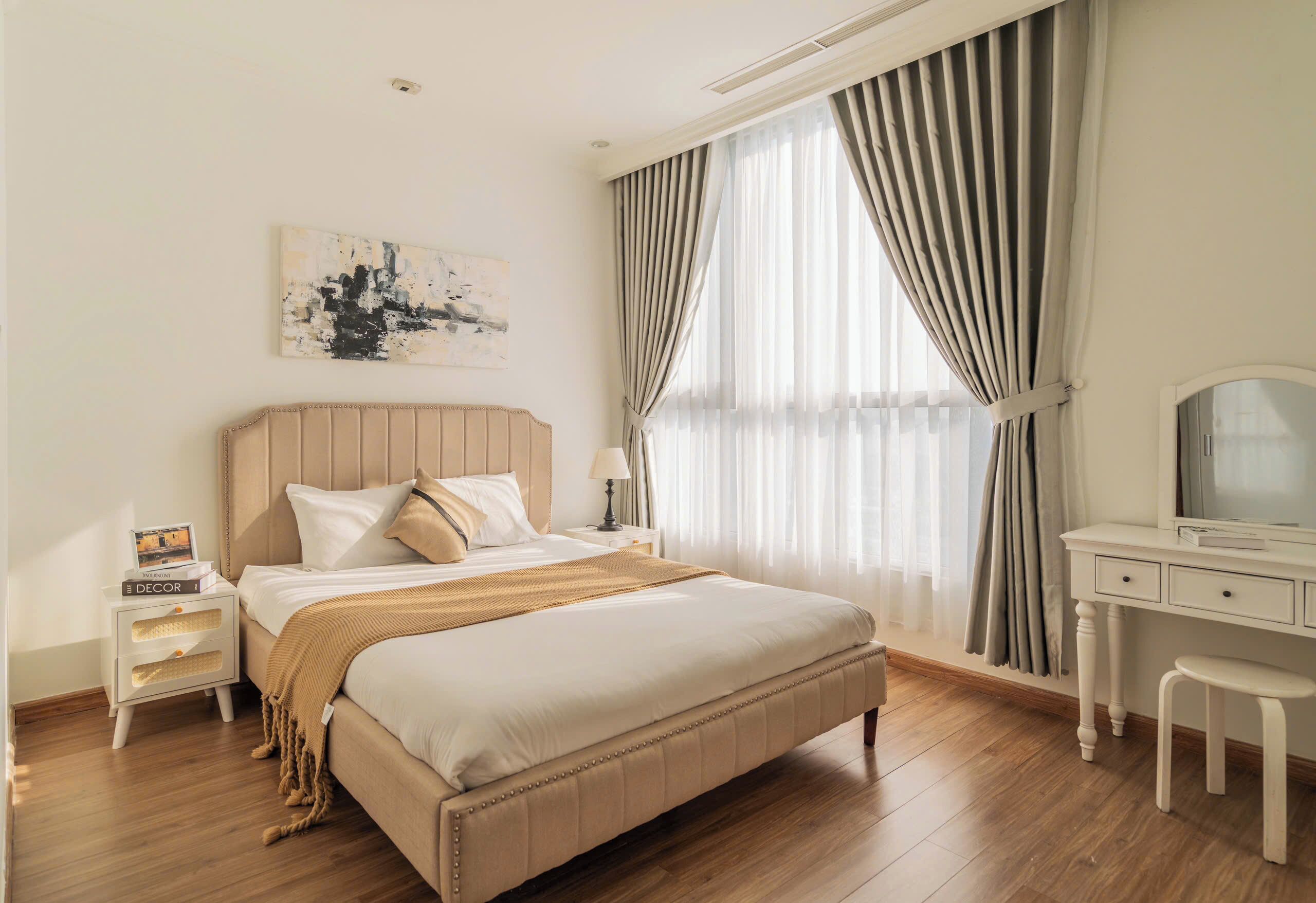 Une chambre à coucher avec un lit, une table de chevet, une commode et un tableau au mur.