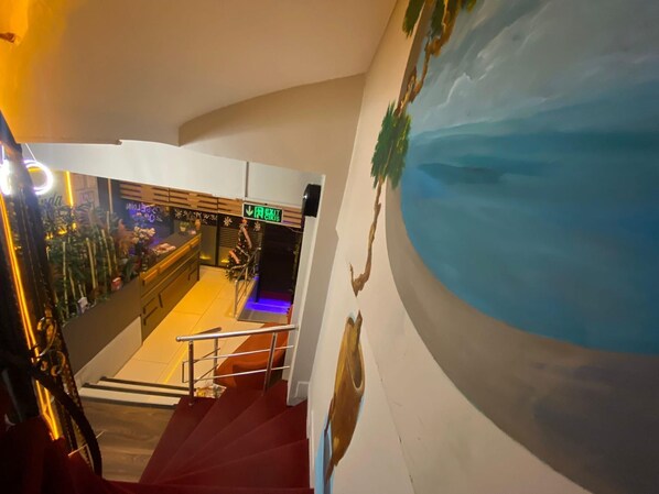 A staircase leading to a bar area with a mural of a landscape.
