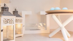 A white table with a tray holding three blue eggs, a white cabinet with intricate cut-out designs, and a white door with a small window. - Darsena Sunset Apartment I by Wonderful Italy (Syracuse)