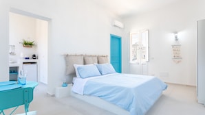 A modern bedroom with a bed, a desk, and a small kitchenette. - Darsena Sunset Apartment II by Wonderful Italy (Syracuse)