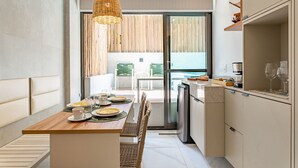 Una cocina moderna con comedor, horno empotrado y vistas a un balcón.