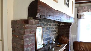 Ein rustikaler Kamin mit Backsteinwand und Holzbalken.