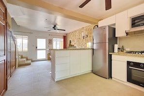 Una cocina equipada con refrigerador, horno y microondas.