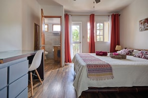 Un dormitorio con cama, escritorio y silla.