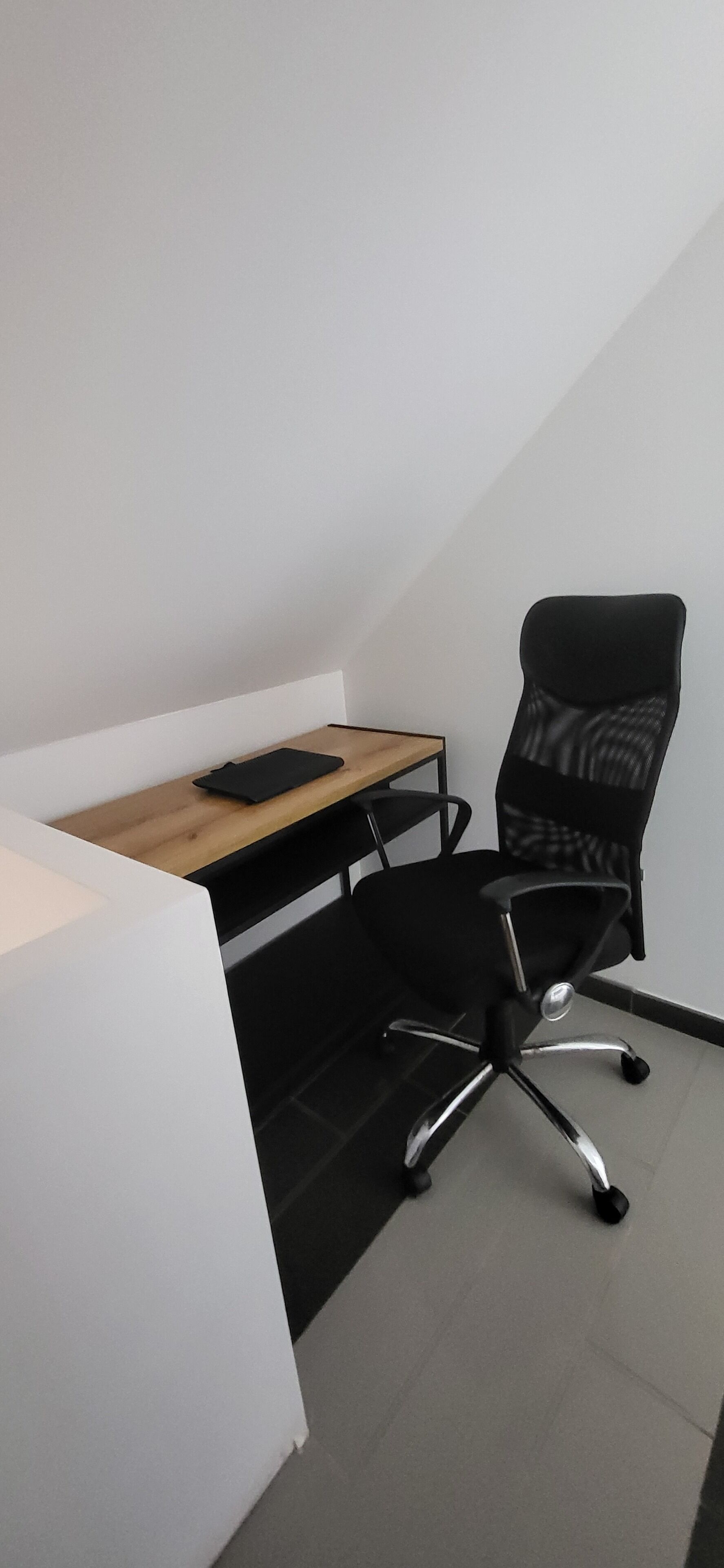 A small office space with a desk and a black office chair.