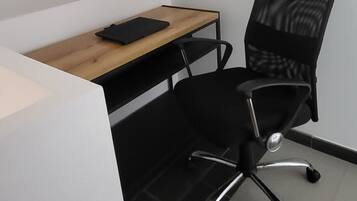 A small office space with a desk and a black office chair.