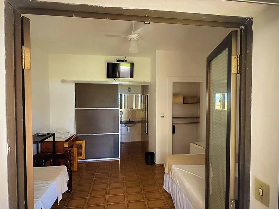 A compact hotel room with a kitchenette, a bed, and a small table.
