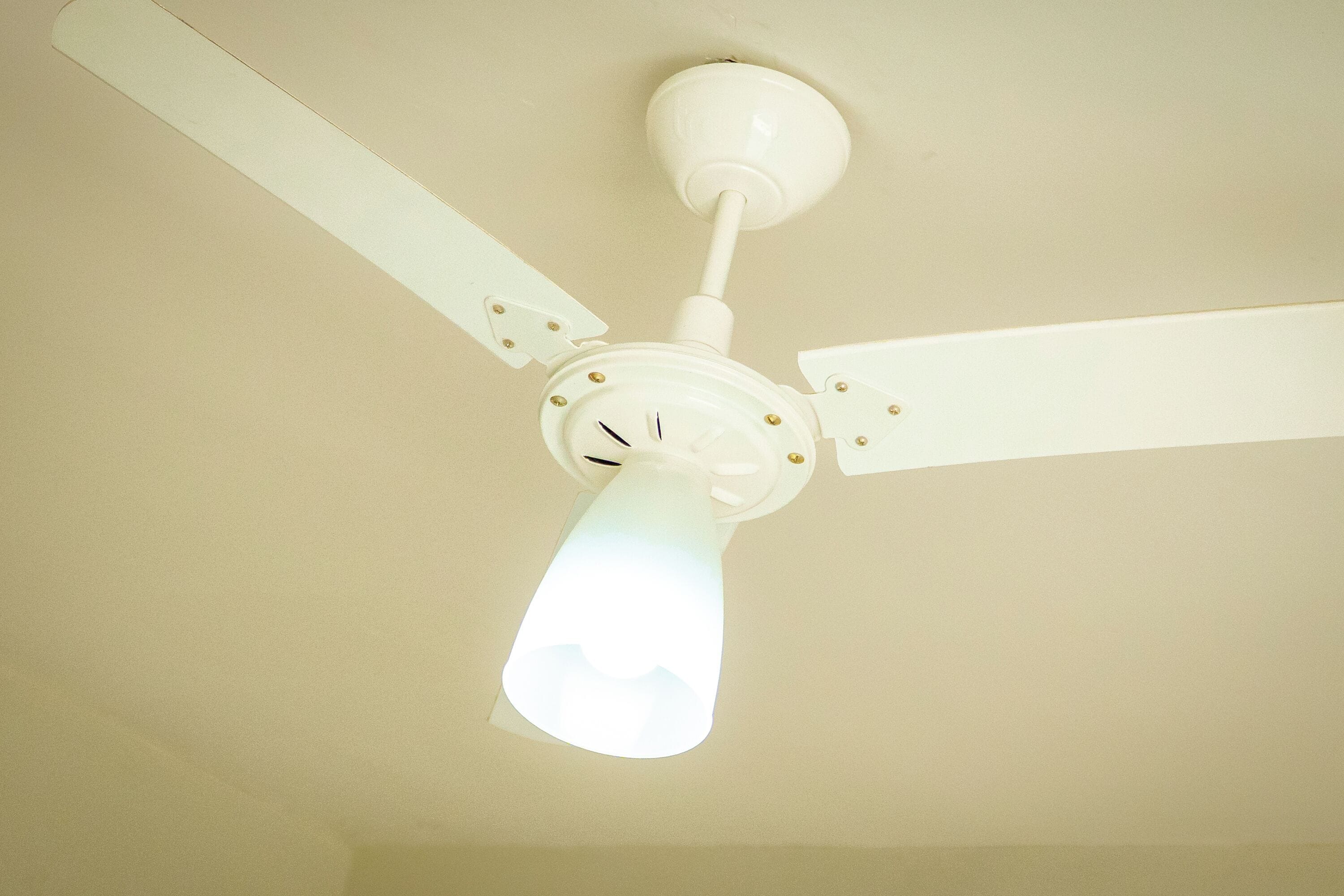 A ceiling fan with three blades and a light fixture.