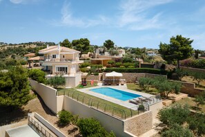 A large house with a swimming pool, surrounded by trees and a hilly landscape. - Hegemoni Villa Porto Heli (Ermionida)
