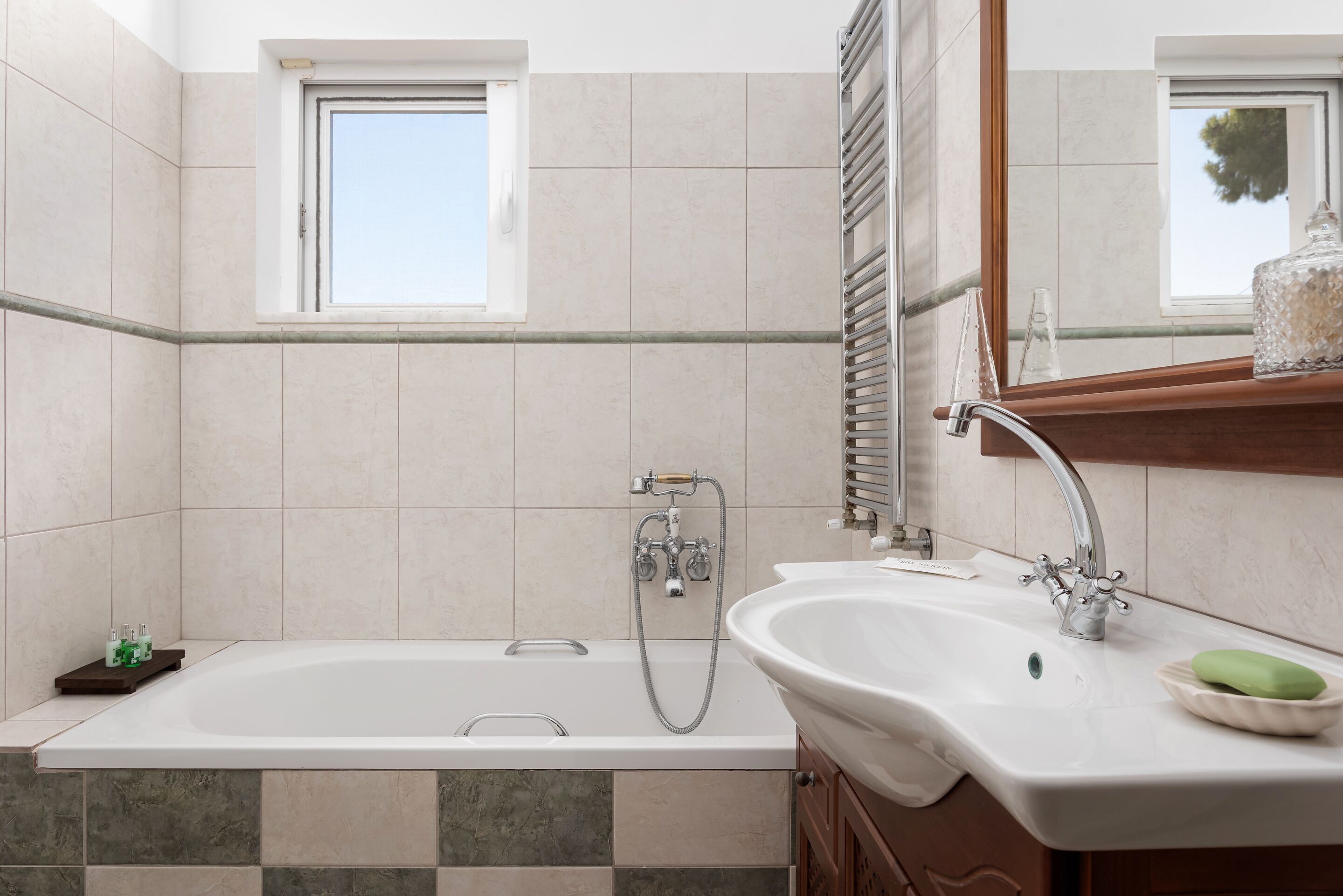 Ein modernes Badezimmer mit einer Badewanne, einem Waschbecken und einem Fenster.