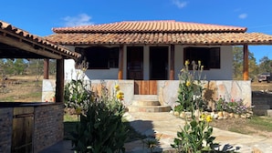 Una casa con tejado de tejas, paredes de piedra y un camino de piedra que lleva a la entrada.