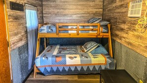 A compact room with a bunk bed, a small table, and a wall-mounted heater. - Oceans 1 - A Frazer Bay Hideaway. Centrally Located! Boat Rentals also Available (Tower)