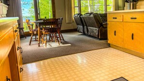 A cozy room with a dining table, chairs, a sofa, wooden cabinets, and a ceiling fan. - Oceans 1 - A Frazer Bay Hideaway. Centrally Located! Boat Rentals also Available (Tower)