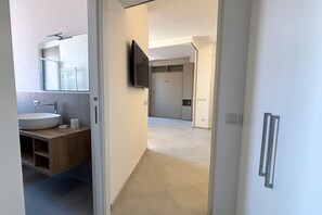 A modern bathroom with a sink, mirror, and toilet paper. - CN014 - Cesenatico, new three-room apartment on the canal port (Cesenatico)