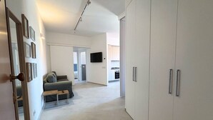A modern apartment with a living area, sofa, coffee table, and a kitchen in the background. - CN014 - Cesenatico, new three-room apartment on the canal port (Cesenatico)