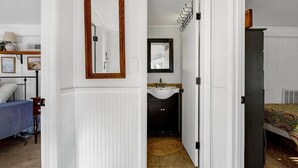 Une chambre à coucher comprenant un lit, une table de chevet, un miroir et une armoire.