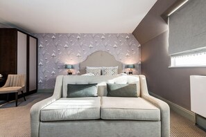 Una camera da letto moderna con un divano letto, due lampade da comodino, carta da parati decorata e un'ampia finestra.