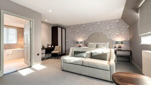 Un dormitorio moderno con sofá cama, escritorio y mesita de noche.