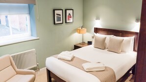 A neatly arranged bedroom with a bed, bedside lamp, and a chair. - Edgbaston Park Hotel & Conference Centre (Birmingham)