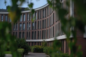 A modern building with a curved facade, multiple windows, and a brick exterior. - Edgbaston Park Hotel & Conference Centre (Birmingham)