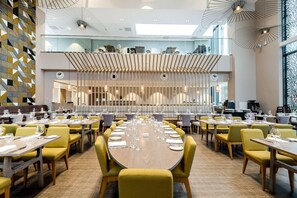 A spacious dining area with multiple tables and chairs, a high ceiling with natural light, and a modern interior design. - Edgbaston Park Hotel & Conference Centre (Birmingham)