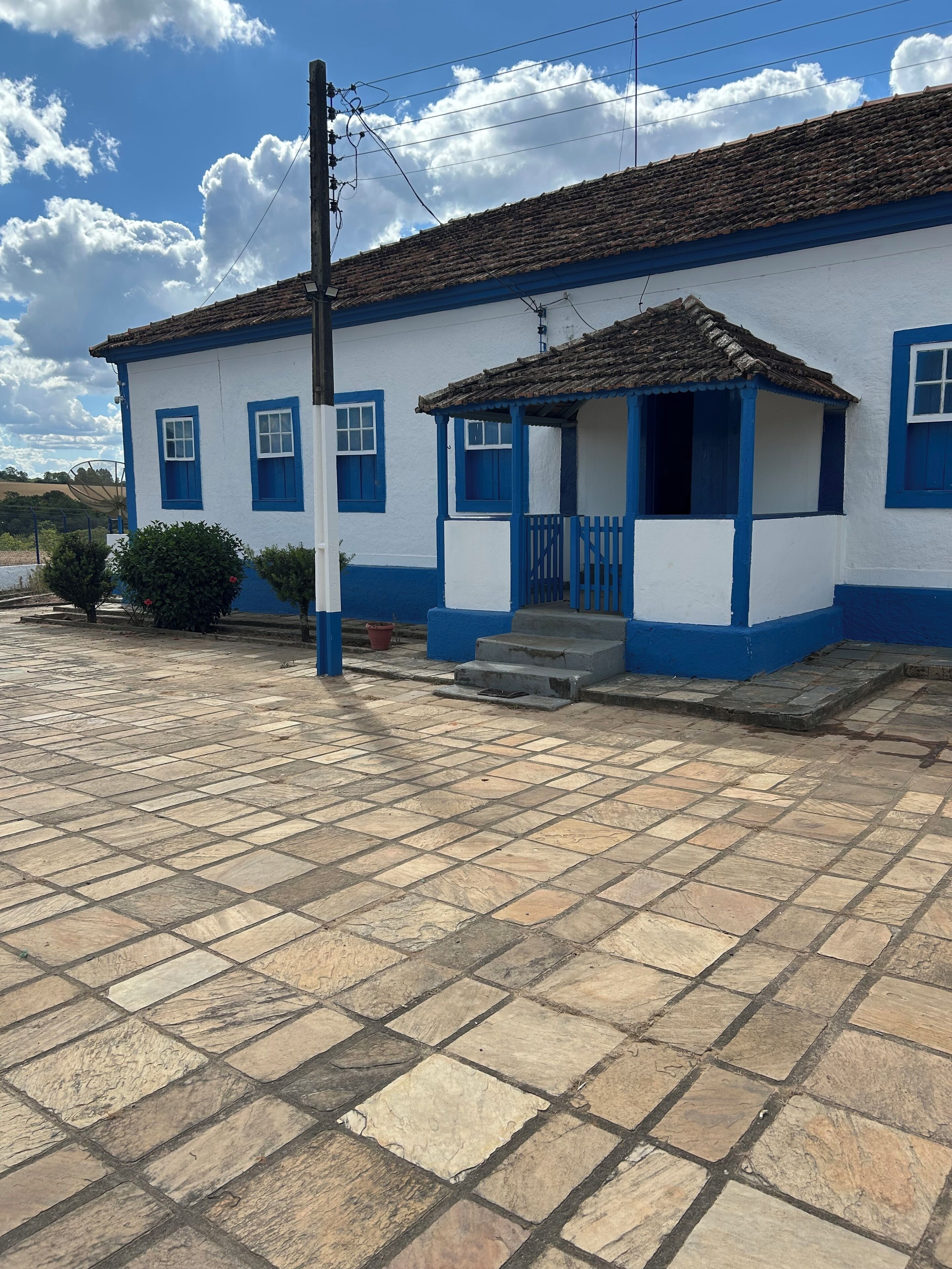 Un bâtiment blanc avec des bordures bleues et une entrée carrelée.