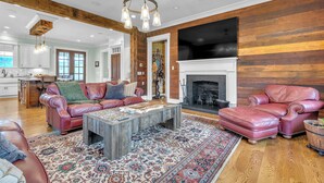 A spacious living room with leather sofas, a coffee table, and a fireplace. - An Upscale 1800's Reset Retreat on Private Acreage with Breathtaking Views (Woodbury)