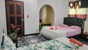 A hotel room with a bed, a chair, a potted plant, and a door. - Hotel Alto Amazonas  (Leticia)