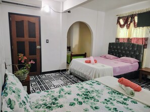 A hotel room with a bed, a chair, a potted plant, and a door. - Hotel Alto Amazonas  (Leticia)