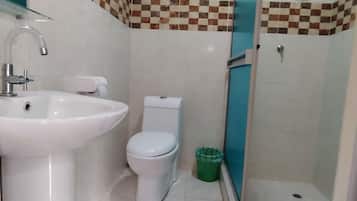 Un baño con lavamanos, inodoro y ducha.