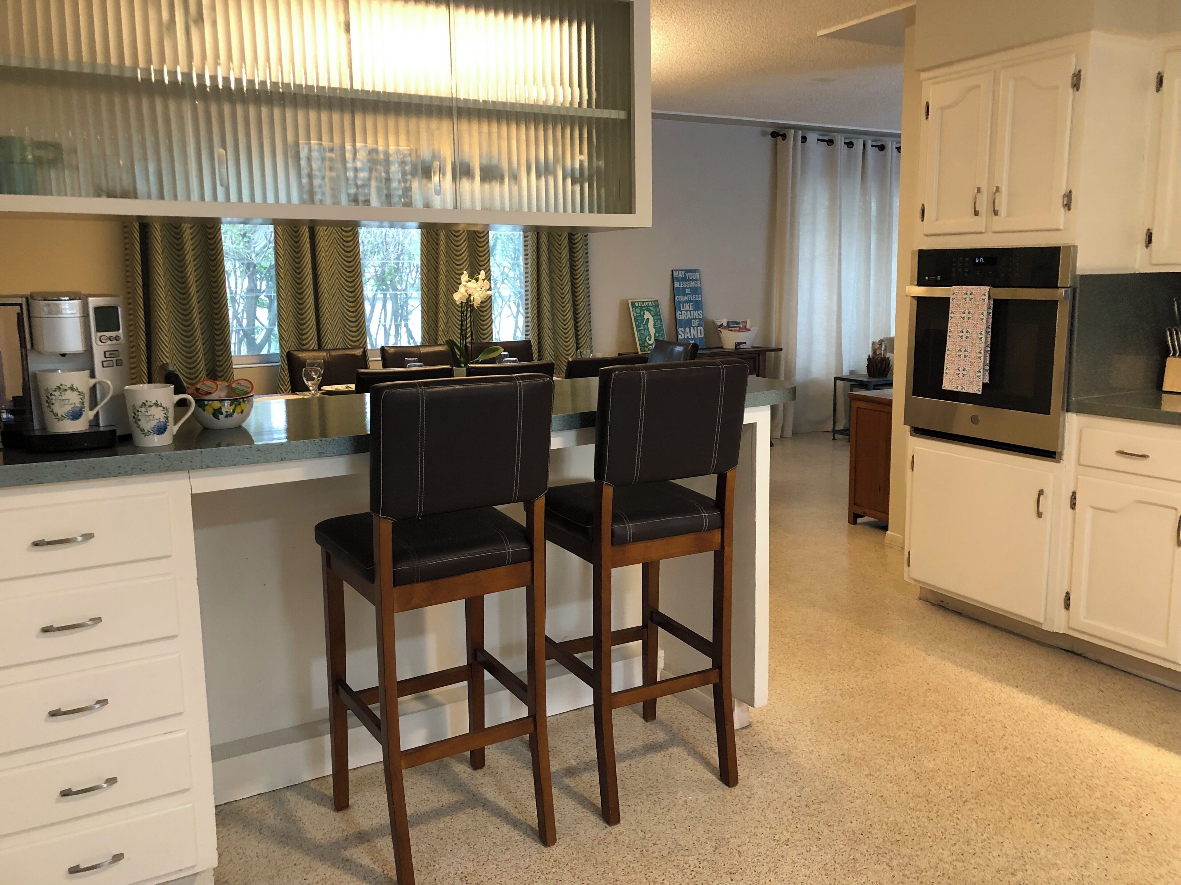 A kitchen with a dining area, featuring a coffee maker, a microwave, and a refrigerator.