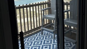 Ein Balkon mit Blick auf Strand und Meer.