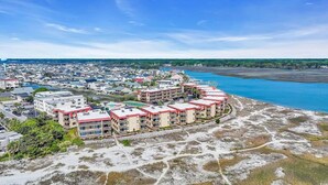 Ein Hotel an der Küste mit mehreren Gebäuden, einem Strandzugang und einer Marina.