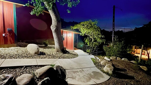 A modern building with a stone pathway leading to a wooden door, surrounded by rocks and a tree. - Spacious and unique Studio suite in  enchanting Three Rivers with WiFi, AC (Three Rivers)