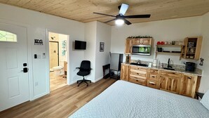 A bedroom with a large bed, wooden ceiling, and a ceiling fan. - Spacious and unique Studio suite in  enchanting Three Rivers with WiFi, AC (Three Rivers)
