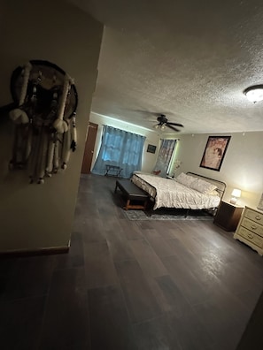 Ein Schlafzimmer mit Bett, Nachttisch und Deckenventilator.