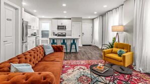 A modern apartment with a living area, kitchen, and dining space.