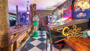 A vintage arcade with pinball machines, including 'Cueball Wizard,' and a checkered floor. - Hummingbird Hideway Peaceful Lake View Cottage (Rockaway Beach)