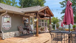 A cozy outdoor seating area with a wooden deck, a covered patio, and a coffee shop sign. - Hummingbird Hideway Peaceful Lake View Cottage (Rockaway Beach)