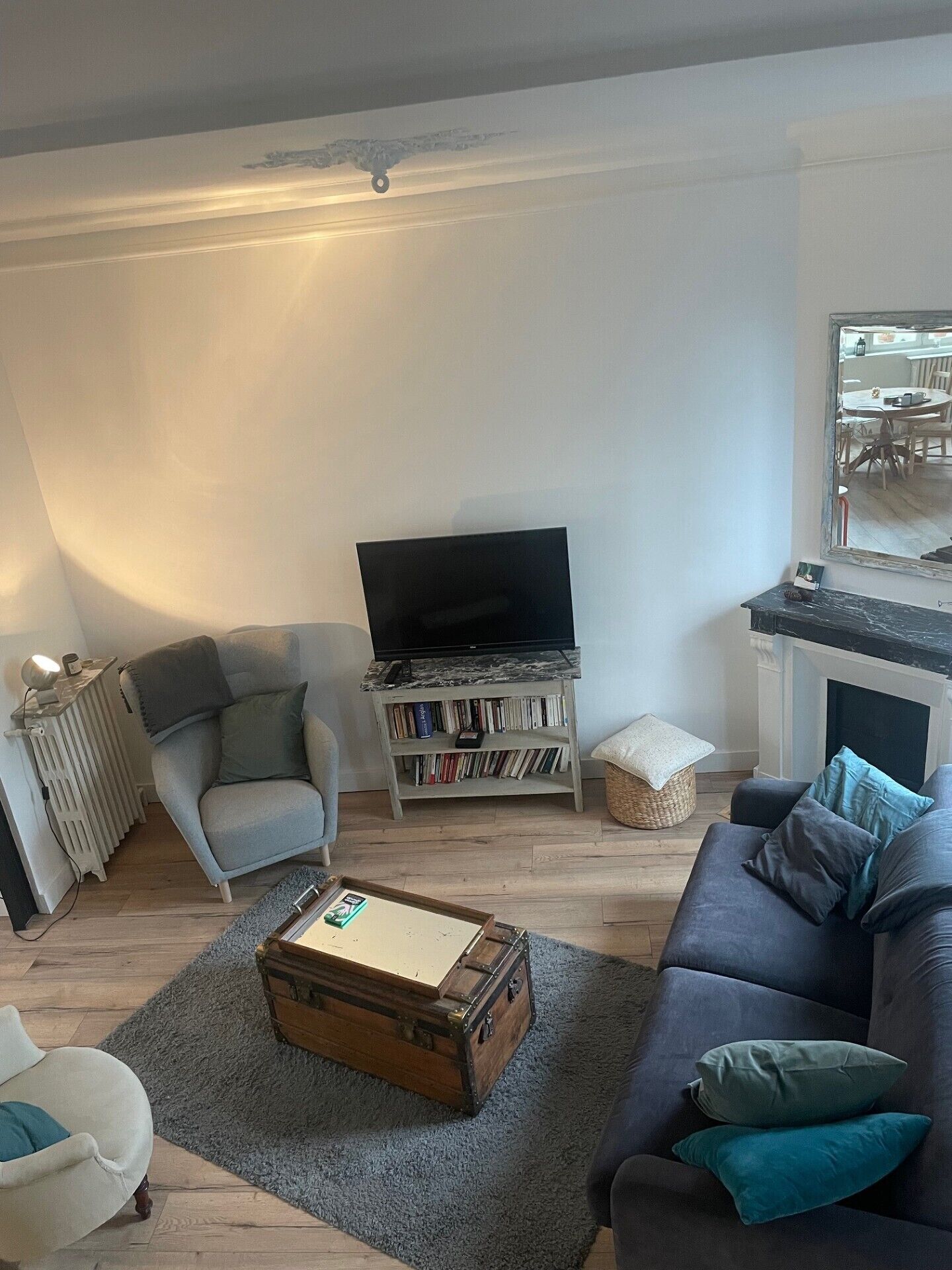 A living room with a sofa, a television, a bookshelf, and a fireplace.