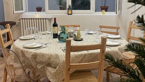 A dining area with a round table set for four, surrounded by wooden chairs.