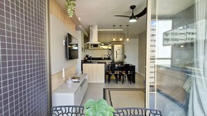 Eine moderne Küche mit Essbereich, Deckenventilator und Blick durch eine Glastür.