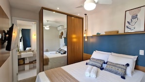 Ein Schlafzimmer mit Bett, Nachttisch und Spiegel.