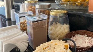 Un buffet de petit-déjeuner proposant divers aliments, notamment des céréales, du lait et des bananes.
