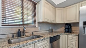 A kitchen with granite countertops, stainless steel appliances, and light-colored cabinetry. - Charming 3BR Beach House w/ Yard & Grill ☀️ (North Myrtle Beach)