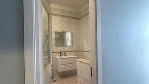 A narrow hallway leading to a bathroom with a sink, mirror, and tiled walls. - Safe Refuge (Macerata Campania)