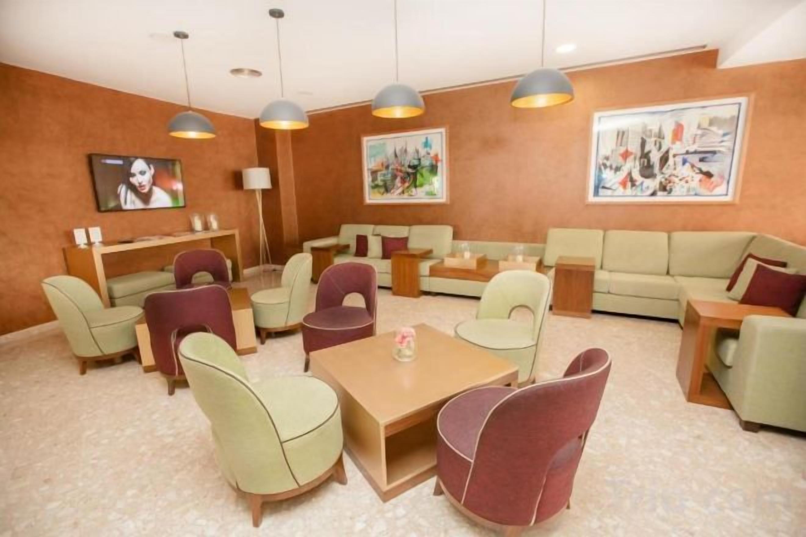 Un salón de hotel con sofás, sillas y una mesa de centro.